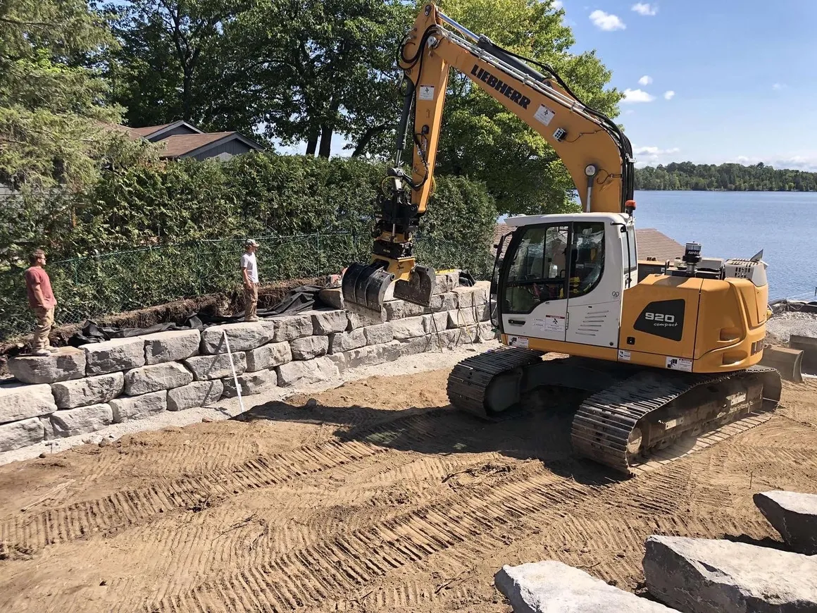 Large armour stone retaining wall built along a lakeshore by Fraser's Excavating