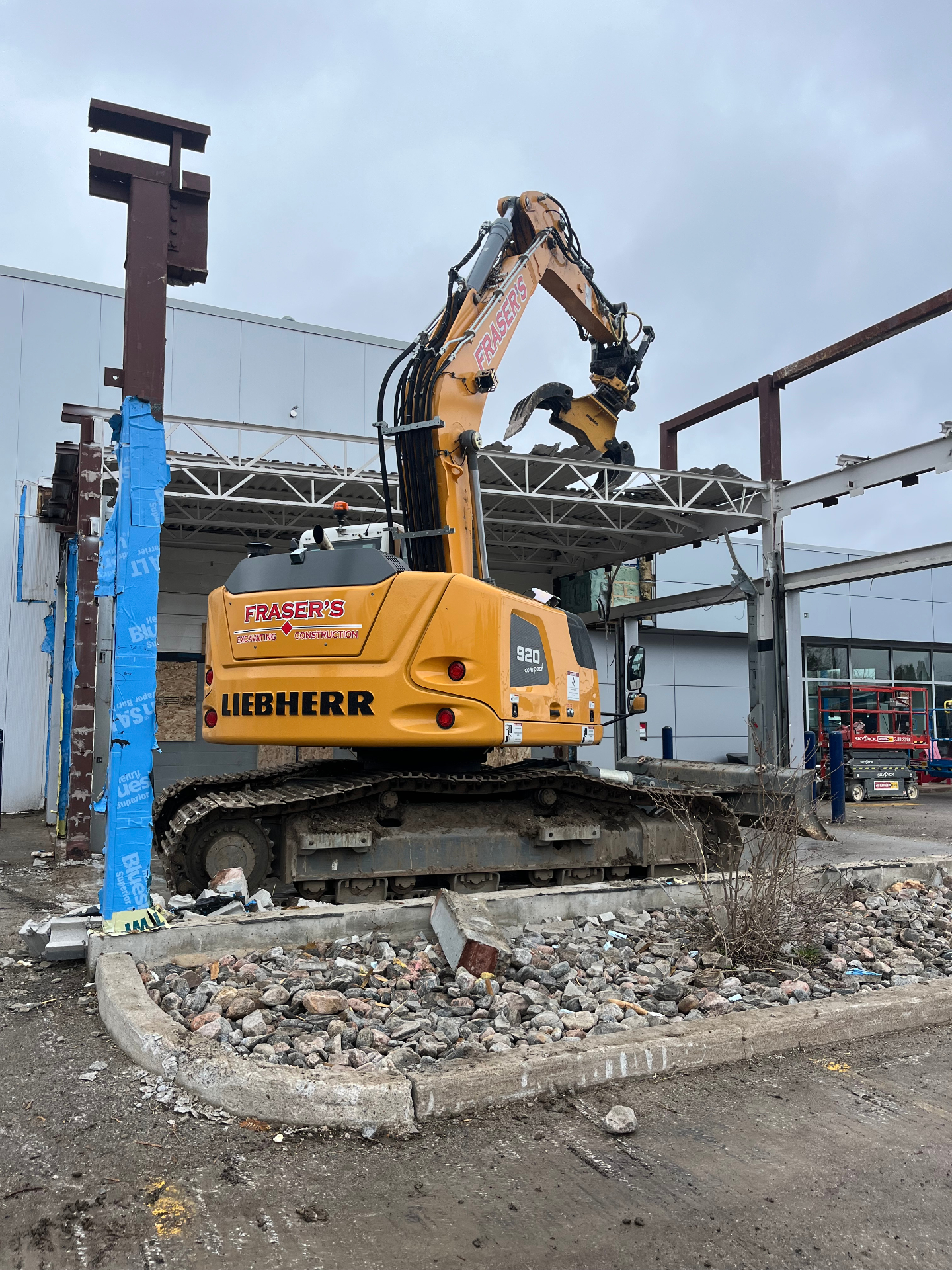 Fraser's Liebherr 920 excavator tearing down a commercial car dealership steel structure