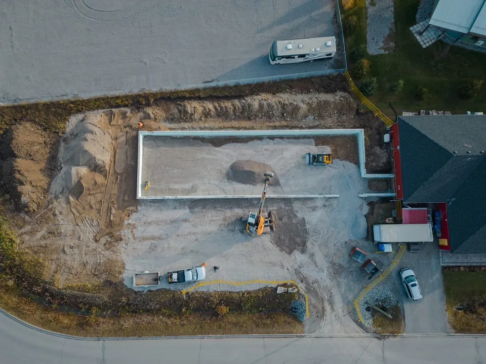 Aerial view of a foundation excavation and concrete forms on a Fraser's job site