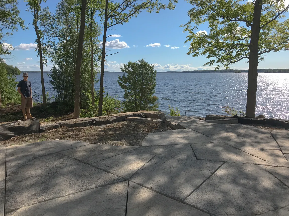 Natural stone patio overlooking the lake, finished by Fraser's landscaping crew