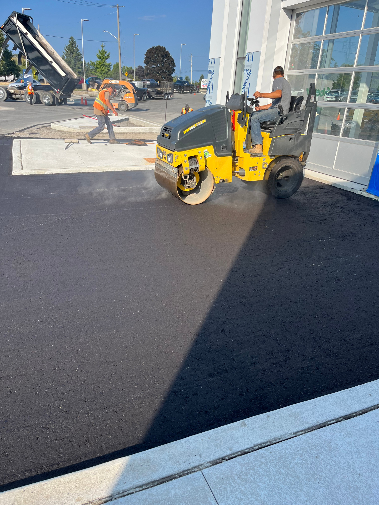 Asphalt being rolled at a commercial dealership site