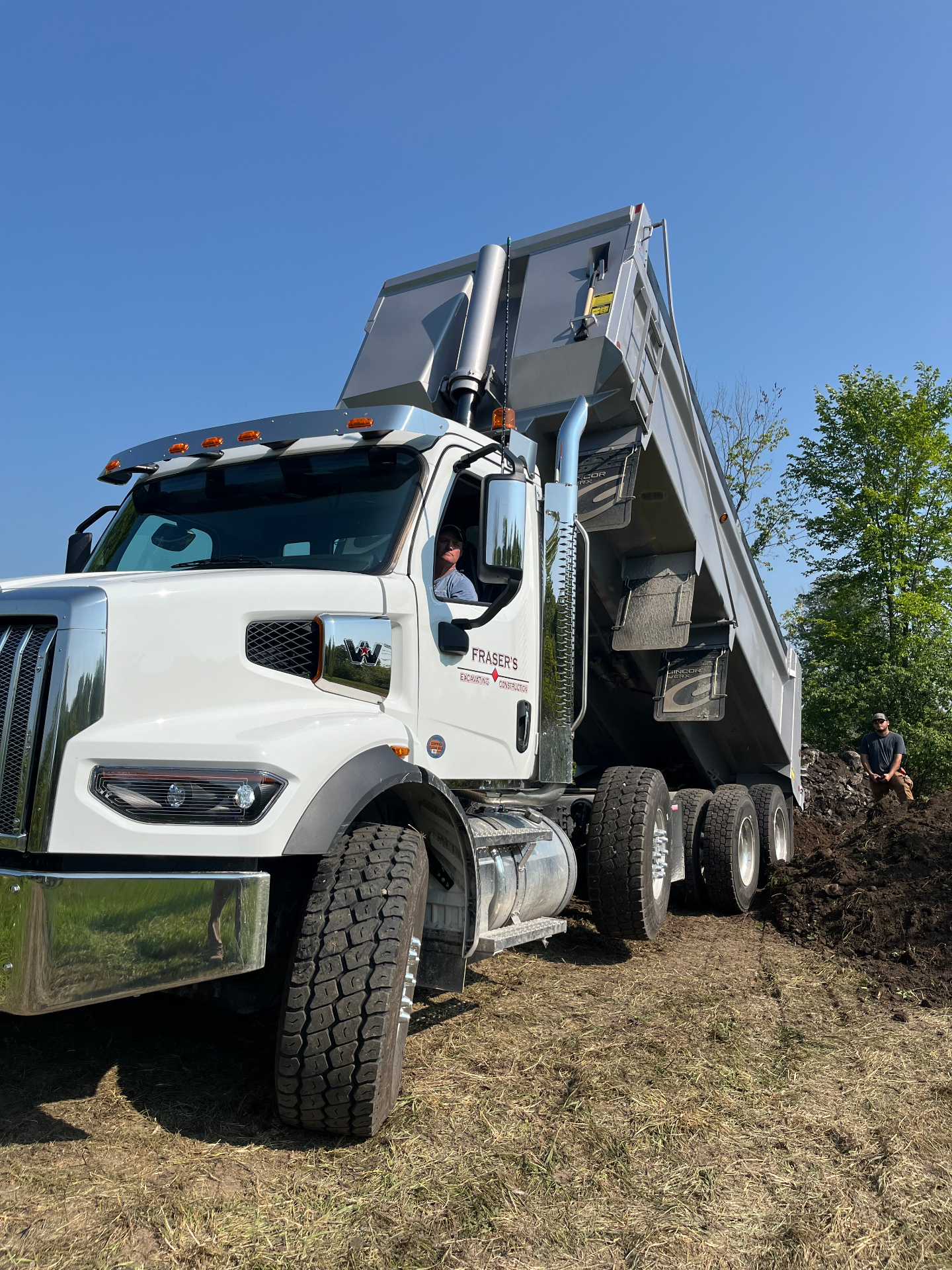 Fraser's Western Star tri-axle dump truck unloading material on a job site